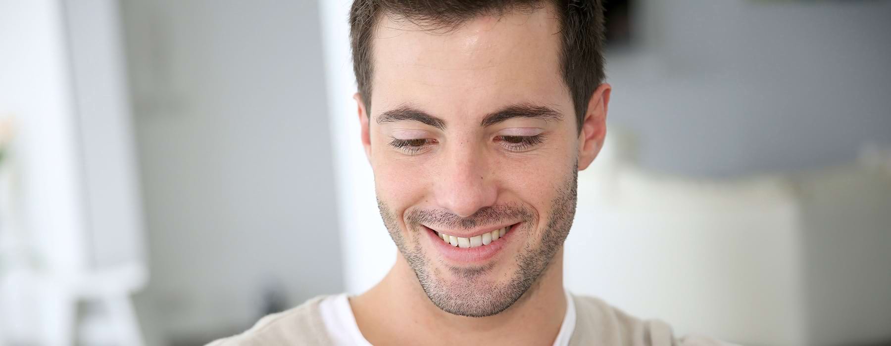 Closeup of a man smiling in his living room. 